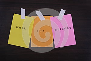 Word quotes of work life balance on colorful sticky papers against wooden textured background