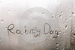 Word RAINY DAY written on the wet glass in rain