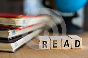 Word of READ spelled with colorful wooden alphabet blocks.