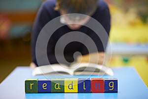 Word Reading Spelt In Wooden Blocks With Pupil Behind