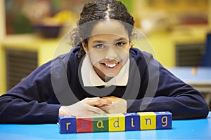 Word Reading Spelt In Wooden Blocks With Pupil Behind