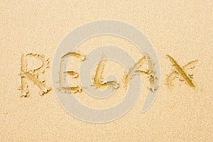 Word Relax written on sand