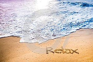 The word RELAX written into the sand photo