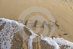 Word RELAX wrote on the sand against background. Message says