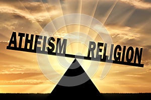 Word religion is more powerful than the word atheism on the scales photo