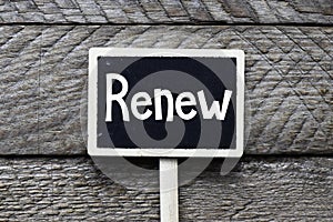 The word Renew written by hand in white chalk on a mini blackboard