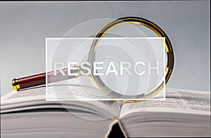 Word research over open book with magnifying glass