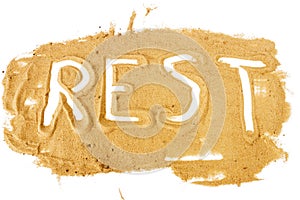 Word REST written on pile of yellow sand