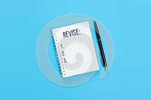 The word Revise is written on a notebook page