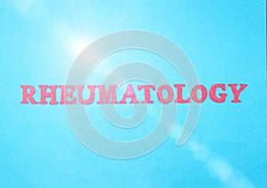 Word Rheumatology in red letters on a blue background. The concept of a section of medicine that treats inflammation and diseases