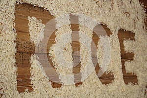 The word RICE written in rice on a wooden background