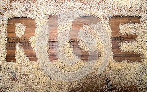 The word RICE written in rice on a wooden background