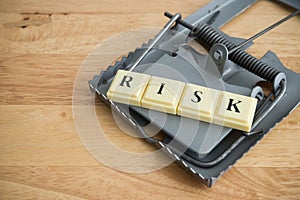 Word RISK in a rat trap on wooden table background copy space. Risk management, risk assessment in business financial