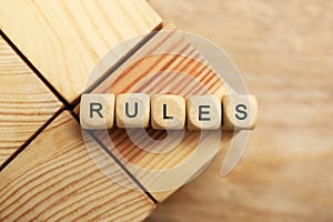 Word Rules made of cubes with letters on wooden blocks, top view