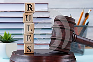 The word RULES on wooden cubes against the background of the judge\'s gavel and stand