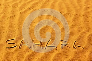 Word Sahara written on the sand