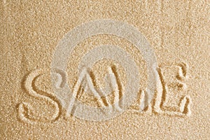 The word sale is painted in the sand. Beach background. Top view. The concept of summer, summer kanikkuly, vacation, holydays