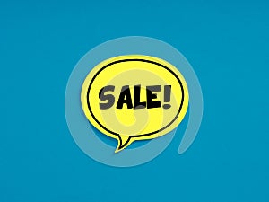 The word sale on yellow speech bubble on blue background. Business shopping discount or promotion announcement concept