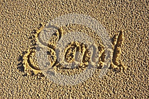 The word 'Sand' written in the sand