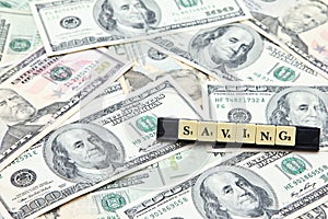 Word saving on pile of US dollar banknotes