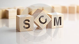 word SCM made with wood building blocks, stock image. background may have blur effect