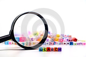 Word `SEARCH` on the magnifying glass with alphabet letter beads background