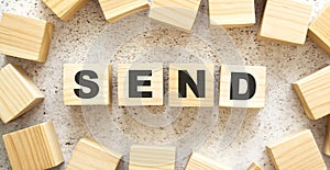 The word SEND consists of wooden cubes with letters, top view on a light background.
