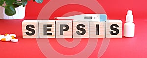 The word SEPSIS is made of wooden cubes on a red background. Medical concept
