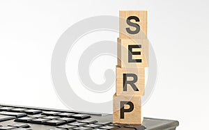 word serp with wooden blocks on keyboard, light white background