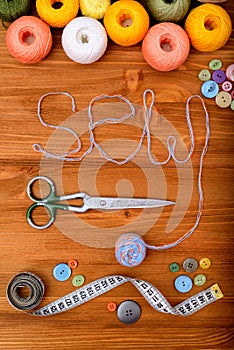 Word sew with sewing tools and accesories on wooden background