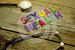 Word SEXUAL HEALTH colorful wooden alphabet letters set and stethoscope on wooden background. Healthcare and medical concept