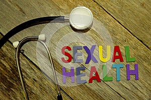 Word SEXUAL HEALTH colorful wooden alphabet letters set and stethoscope on wooden background. Healthcare and medical concept