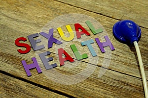 Word SEXUAL HEALTH colorful wooden alphabet letters set and toy stethoscope on wooden background. Healthcare and medical concept