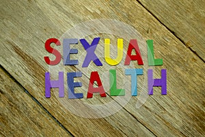 Word SEXUAL HEALTH colorful wooden alphabet letters set on wooden background. Healthcare and medical concept