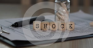 Word SHOCK composed of wooden dices photo