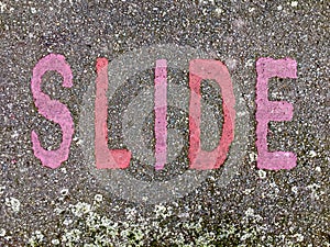 The word SLIDE on the floor in a kids park