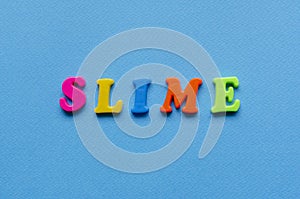 word slime on blue paper background.