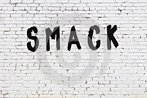 Word smack painted on white brick wall