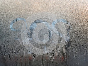 The word sos was written on the wet glass of the window.
