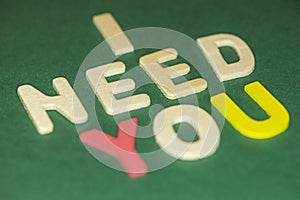 The word spelling to `I need you` on green background