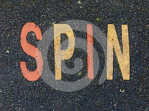 The word SPIN on the floor in a kids park