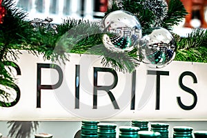 The word spirits on a luminous banner in the alcohol department of a supermarket. Christmas store decorations, Christmas sales