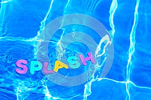 Word SPLASH floating in a swimming pool