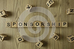 Word sponsorship from wooden blocks on desk photo