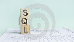 the word sql structured query language, lined with wooden blocks.