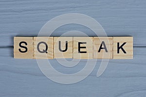 word squeak made of small gray wooden letters