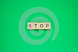 Word stop. Top view of wooden blocks with letters on green surface