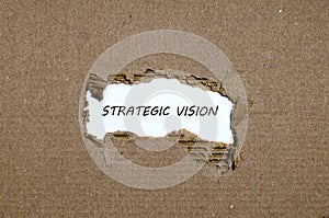 The word strategic vision appearing behind torn paper
