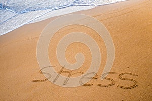 The word STRESS written in the sand