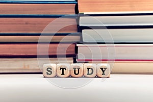 The word study on wooden cubes with stacked books background. Education, school and learning concept